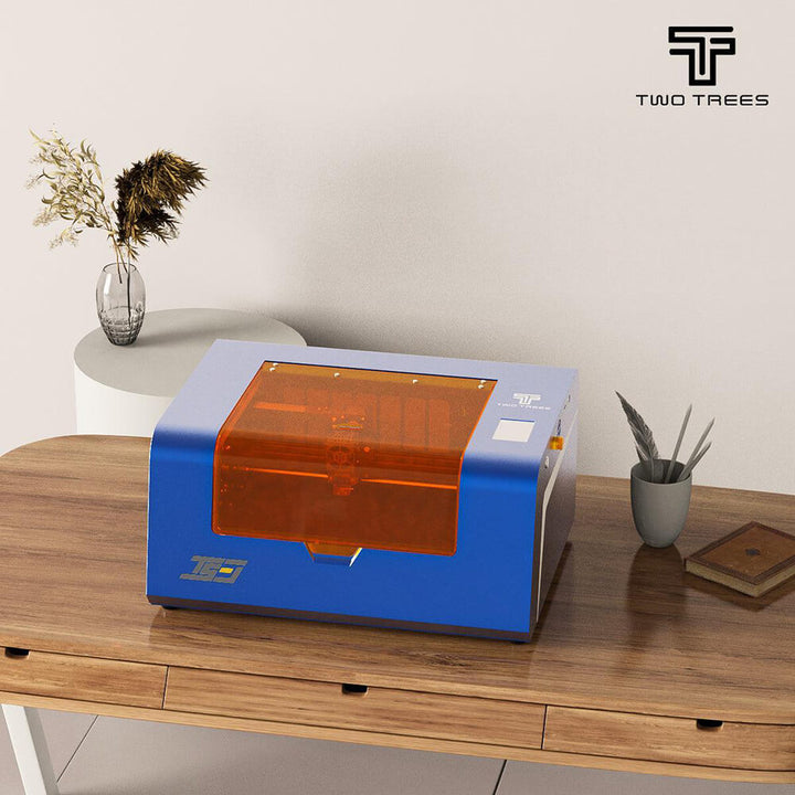 Blue and orange machine on a wooden table with 'Two Trees' branding. Twotrees TS3 10W Black Enclosed Diode Laser Engraver - High Precision & Safety | Twotrees Laser Engraver