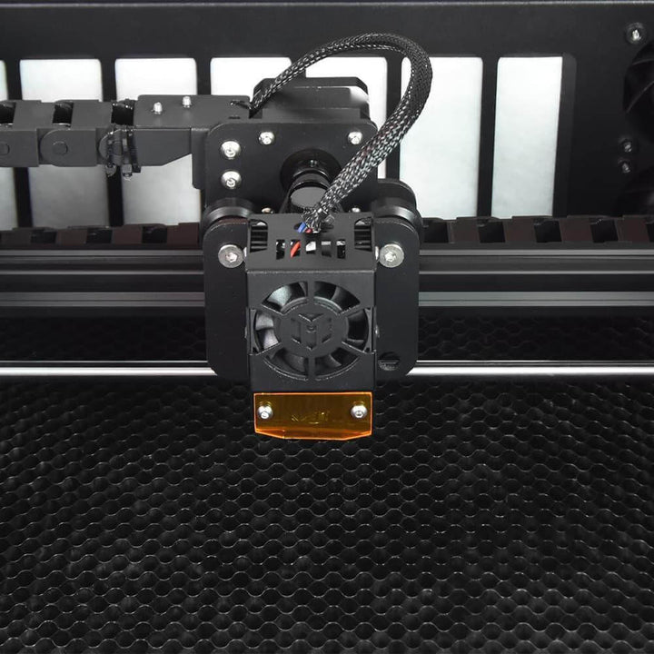 Close-up of a 3D printer's extruder mechanism on a textured black surface. Twotrees TS3 10W Black Enclosed Diode Laser Engraver - High Precision & Safety | Twotrees Laser Engraver